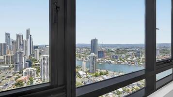 A high-rise building with a view of a cityscape and a river.