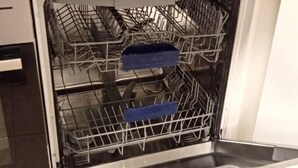 An open dishwasher with a wooden countertop above it. - Two bedrooms apartment with free underground parking place (Etterbeek)