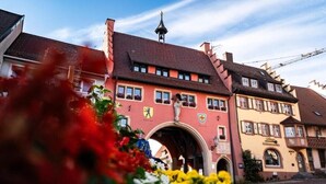 Ein traditionelles europäisches Gebäude mit einem markanten Bogen, einem Glockenturm und einem Schild, das ein Restaurant anzeigt.
