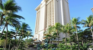 A tall hotel with a modern design, surrounded by palm trees and tropical vegetation. - Waikiki 1BR Retreat at Kalia Suites – Full Kitchen, Walk to Beach & Ala Moana (Honolulu)