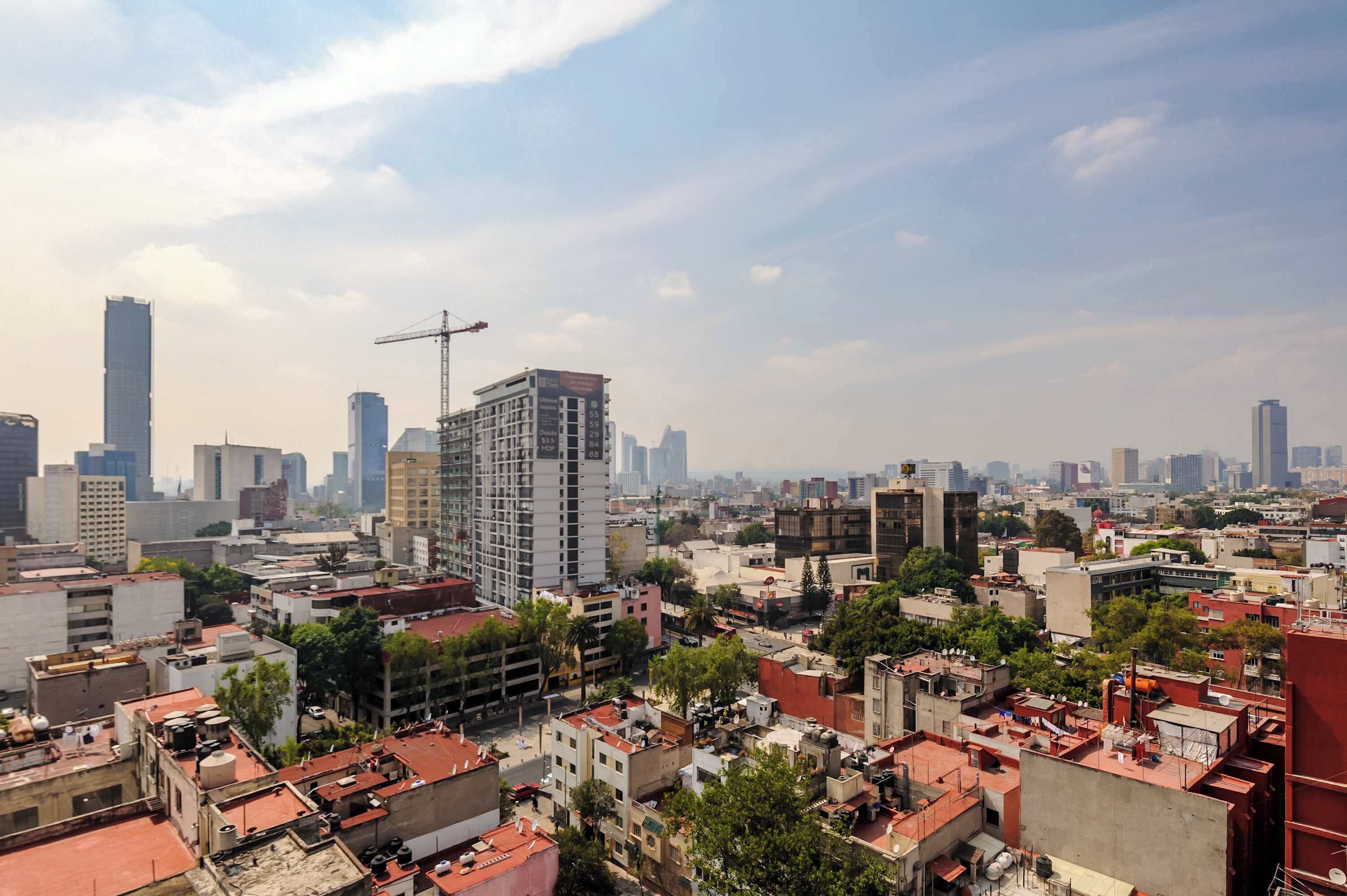 A cityscape with high-rise buildings, a construction crane, and dense urban development.