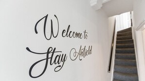 A wall with the text "Welcome to Stay Antfield" in a decorative font. - The Crews Quarters Anfield - Sleeps 10 - Modern (Merseyside)