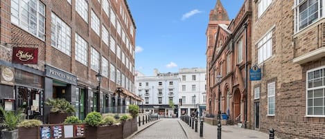 A cobblestone street lined with historic brick buildings, including a Princes House and a Regent House.