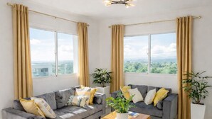 Een moderne woonkamer met een zithoek, een salontafel en een gele fauteuil.