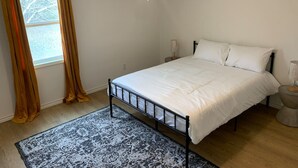 A bedroom with a bed, a ceiling fan, a window with curtains, and a rug. - MSU Sweet Spot: Cozy 2BR w/Patio (Starkville)