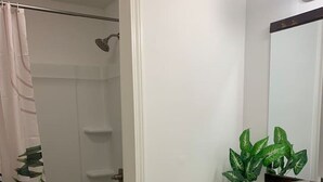 A bathroom with a toilet, sink, and shower. - MSU Sweet Spot: Cozy 2BR w/Patio (Starkville)