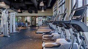 Una palestra con tapis roulant, macchinari per pesi e un'area dedicata ai massaggi.