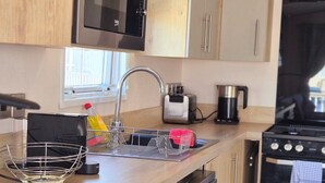 Una cucina compatta con microonde, tostapane, bollitore e forno.