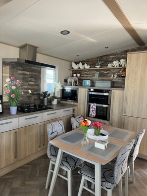 A modern kitchen with a central island, built-in appliances, and decorative items. - Whitstable’s Tranquility (Whitstable)