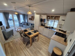 A compact, modern living space with a dining area, kitchen, and seating area. - Whitstable Sun Seeker (Whitstable)
