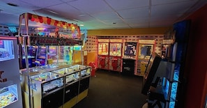 A row of arcade games with a toy carnival theme, including claw machines and racing games. - Whitstable Sun Seeker (Whitstable)