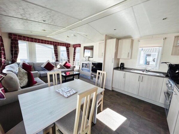 A compact living space with a dining area, kitchenette, and seating area.
