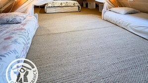 Een gezellig slaapkamer op zolder met een schuine kap, een bed met hemelbed en een dakraam.