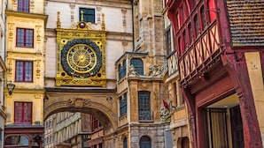 Eine historische Straße mit aufwendiger Architektur, darunter ein markanter Glockenturm und ein traditioneller Bogen.