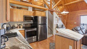 A modern kitchen with wooden cabinets, stainless steel appliances, and a wooden ceiling. - Lakefront Log Cabin With Private Dock, Two Decks & Cozy Comfort at 35mm in Sunrise Beach (Sunrise Beach)