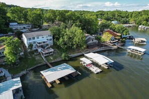 An aerial view of a lakeside property with docked boats, a bridge, and various buildings. - Sleeps 30! Decks, Docks & Lake Life! (Sunrise Beach)