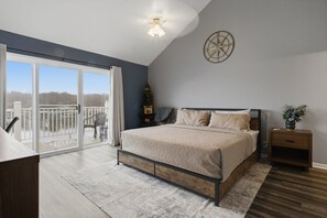 A bedroom with a large bed, a wooden nightstand, a wall clock, and a ceiling light. - Lake Views & Loft Retreat for Kids w/ 12x30 Slip at Mm11 (Sunrise Beach)
