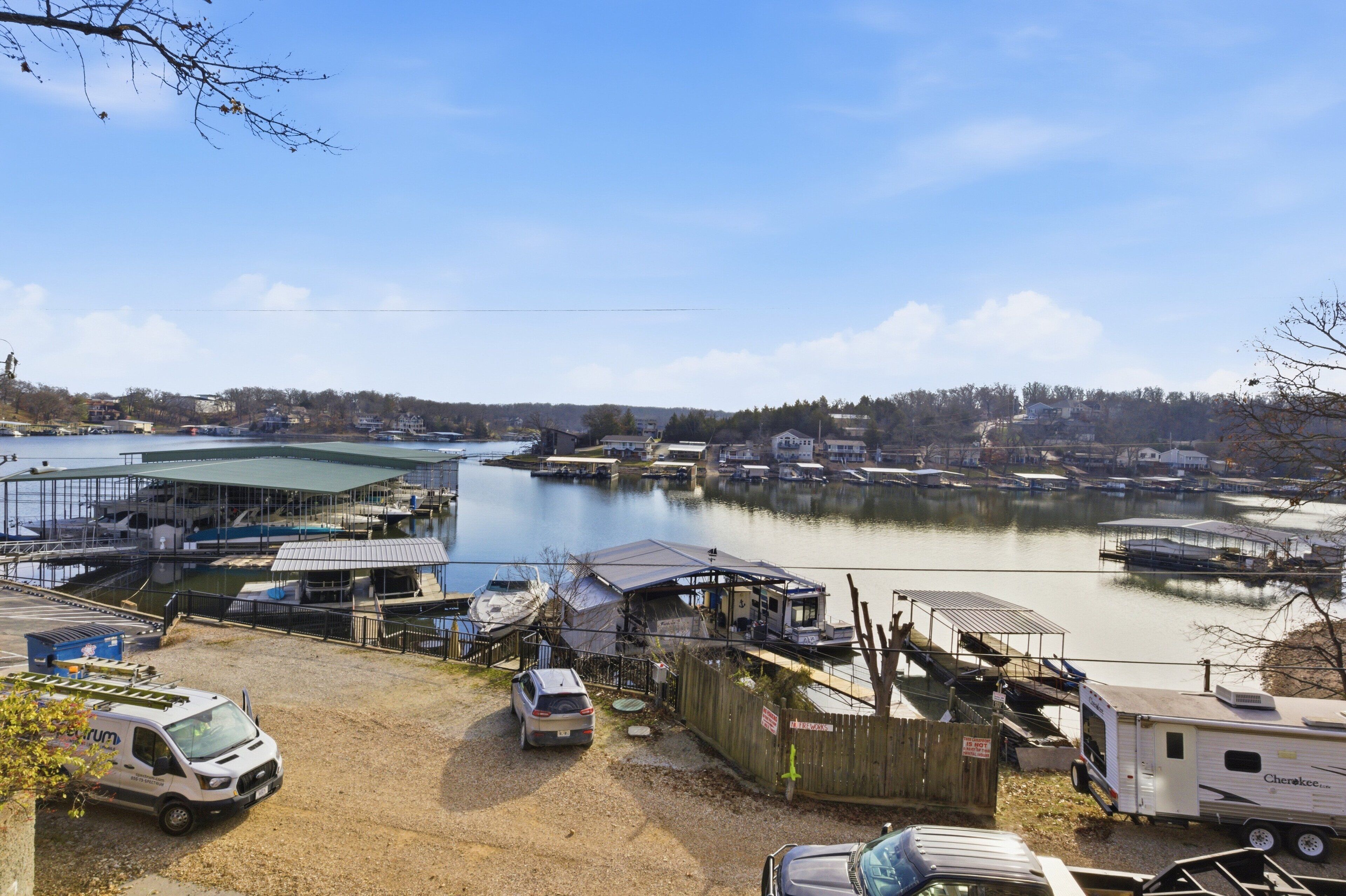 A marina with boats docked, a covered boat house, and a small building with a sign.