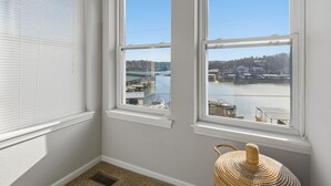 Una habitación con dos ventanas que dan a un cuerpo de agua y un muelle.