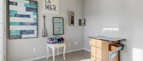 A well-lit room with a desk, chair, and artwork on the walls.
