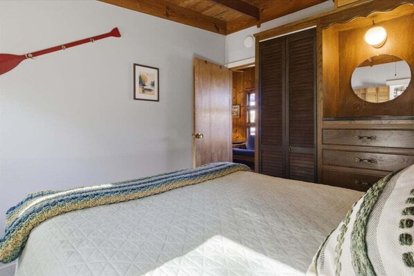A bedroom with a bed, a wooden wardrobe, a mirror, and a door. - Lakefront Home w/ Private Dock, Boat Slip, Firepit & Sunset Views at MM5 (Gravois Mills)