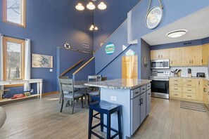 A compact kitchen with a central island, wooden cabinets, and modern appliances. - Lakefront House w/ Private Dock, 2 Slips, Dock Bar & Kayaks at 2mm (Lake Ozark)