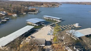A marina with docks and boats, surrounded by hills and a clear sky. - Runabout Retreat (Osage Beach)