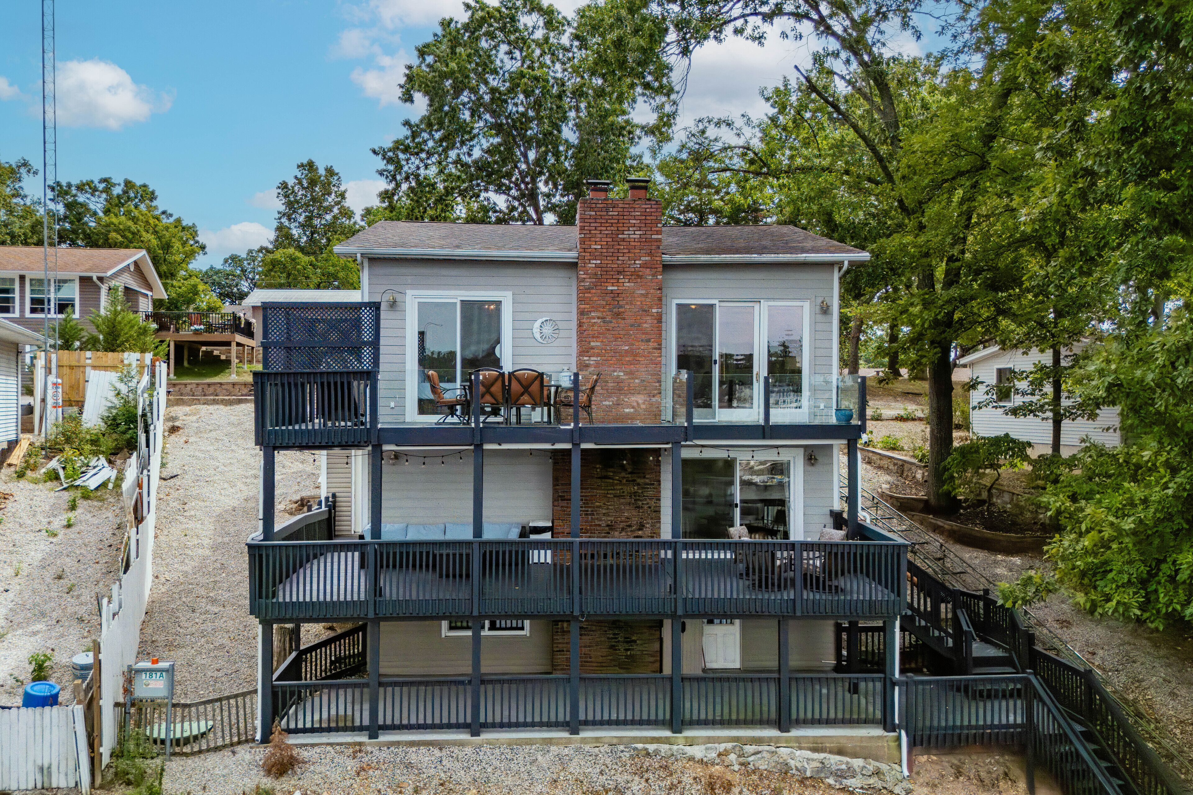 A two-story house with a balcony and a brick chimney.