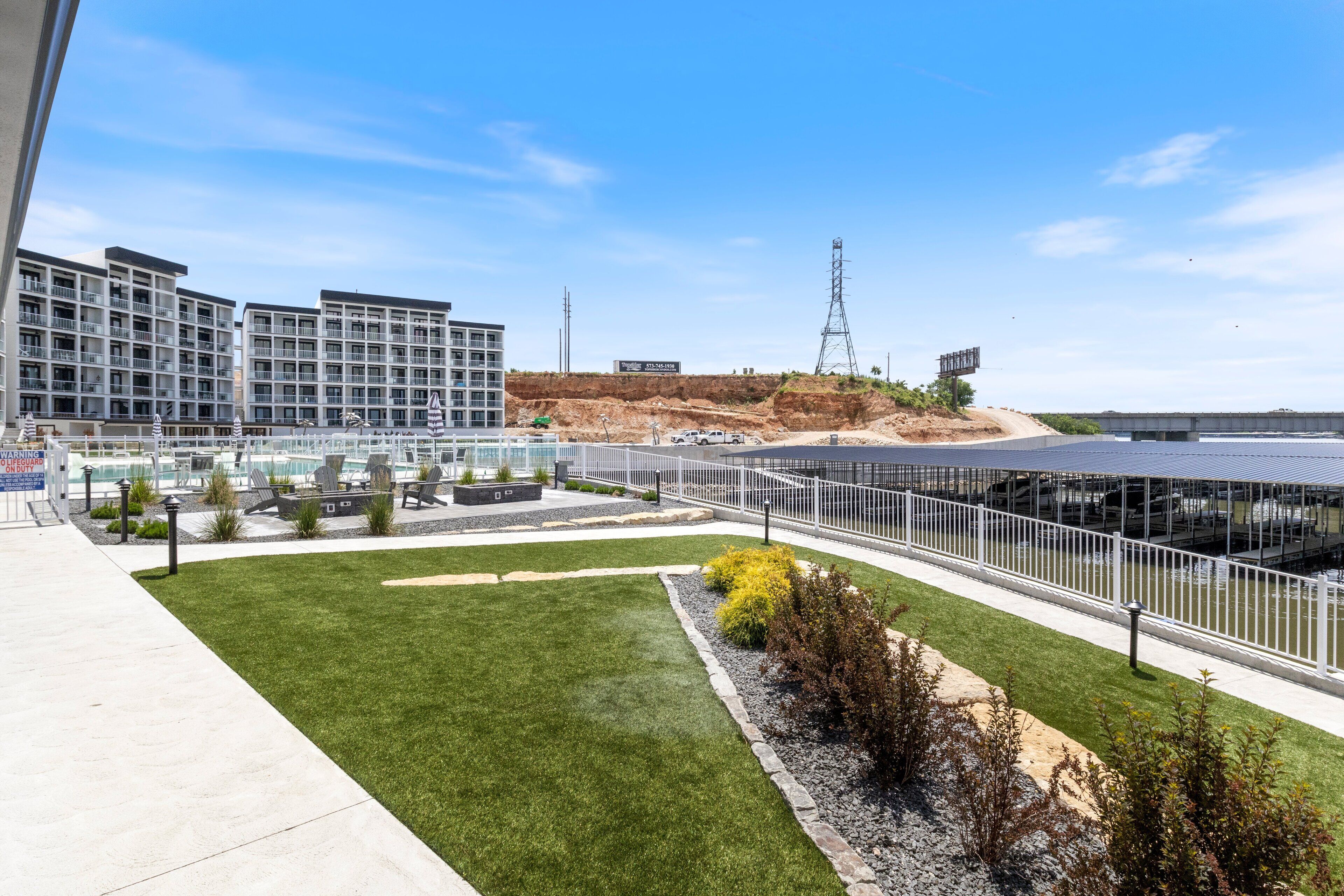 Ein modernes Hotel mit Dachgarten, Schwimmbad und Blick auf eine Baustelle.