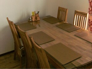 A dining table with six wooden chairs, a knife block, and placemats. - maINZ - charm meets cordiality (Stadl an de Mur)