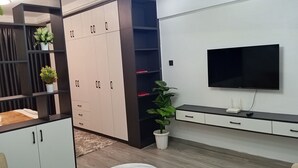 Una sala de estar moderna con televisor, sofá, mesa de centro y unidades de almacenamiento integradas.