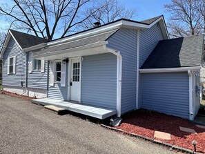 A single-story house with a front porch, a garage, and a small attached shed. - Farmhouse in the Heart of DowntownAuburn Hills (Auburn Hills)