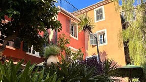 A courtyard with a stone wall, potted plants, and outdoor seating. - Dedans-dehors - 10 min from the beach, wifi, air conditionated (Bormes-les-Mimosas)