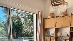 A modern living room with a sofa, chairs, a coffee table, and a bookshelf. - Dedans-dehors - 10 min from the beach, wifi, air conditionated (Bormes-les-Mimosas)