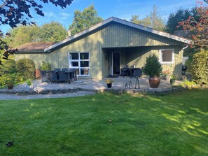 A single-story building with a covered patio area, a door, and a window. - Holiday house located in a forest area (Glesborg)