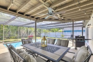 A covered patio with a pool table, chairs, and a ceiling fan. - Elegant Coastal Oasis Near Beaches & Private Pool (Holiday)