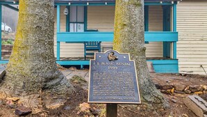 A historical plaque in front of a building with a blue porch and a well-maintained lawn. - Immerse in Julian Cozy Cabin w Fireplace & Deck (Julian)