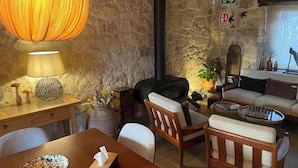 Un salon chaleureux avec une cheminée, une table en bois, un canapé et une lampe.