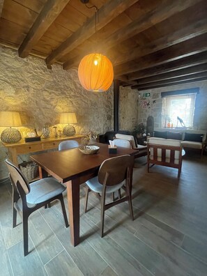 Un comedor rústico con una mesa de madera, sillas y una lámpara colgante.