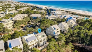 An aerial view of a coastal residential area with houses, a beach, and a clear sky. - Sol y Sombra (Santa Rosa Beach)