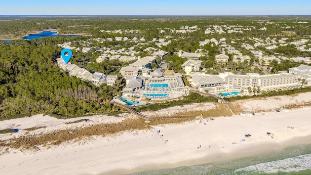 An aerial view of a coastal resort with multiple buildings, a beach, and a large pool area. - Sol y Sombra (Santa Rosa Beach)