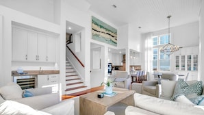 A spacious living area with a staircase, a kitchen, and a dining area. - Sol y Sombra (Santa Rosa Beach)