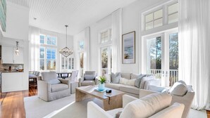 A spacious living room with a large sofa set, a coffee table, and a dining area with a table and chairs. - Sol y Sombra (Santa Rosa Beach)