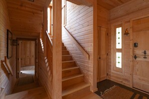 Un escalier en bois menant à une porte dotée d’une fenêtre.
