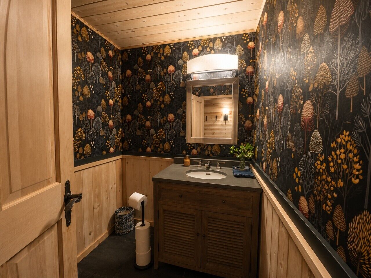 A bathroom with a wooden vanity, a sink, a mirror, and a toilet.