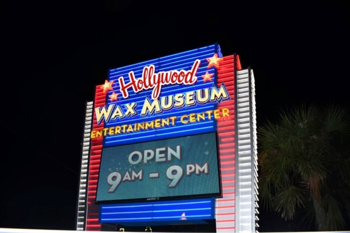 A sign for the Hollywood Wax Museum with the text "OPEN 9AM - 9PM".