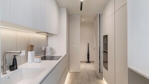 A modern kitchen with a large island, built-in appliances, and a sleek design. - Savoy Monumentalis XI – Luxury with sea view (Funchal)