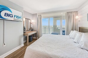 Ein Hotelzimmer mit Bett, Schreibtisch, Spiegel, einem Fenster mit Vorhängen und einem Schild für Big Fish Rentals.
