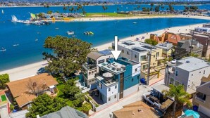 Zona residencial costera con playa, barcos y una mezcla de arquitectura moderna y tradicional.