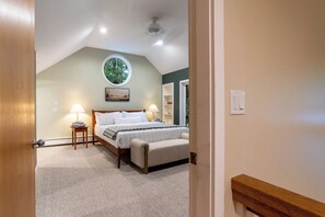 A bedroom with a bed, bedside tables, a window, and a ceiling fan.